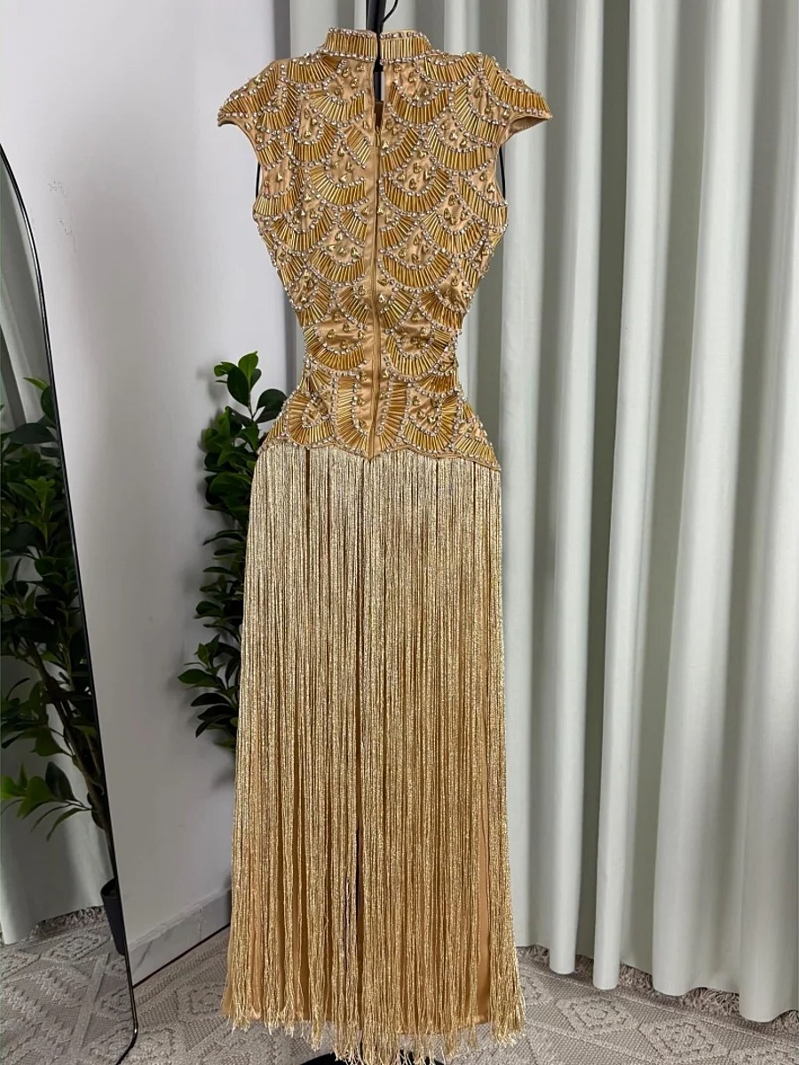 Robe dorée à franges perlées présentée sur mannequin