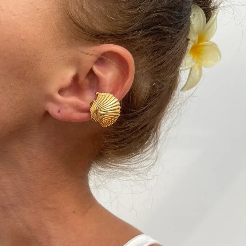 Coquillage doré en clip porté sur l'oreille