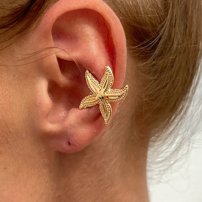 Grande étoile de mer dorée en clip portée sur le cartilage