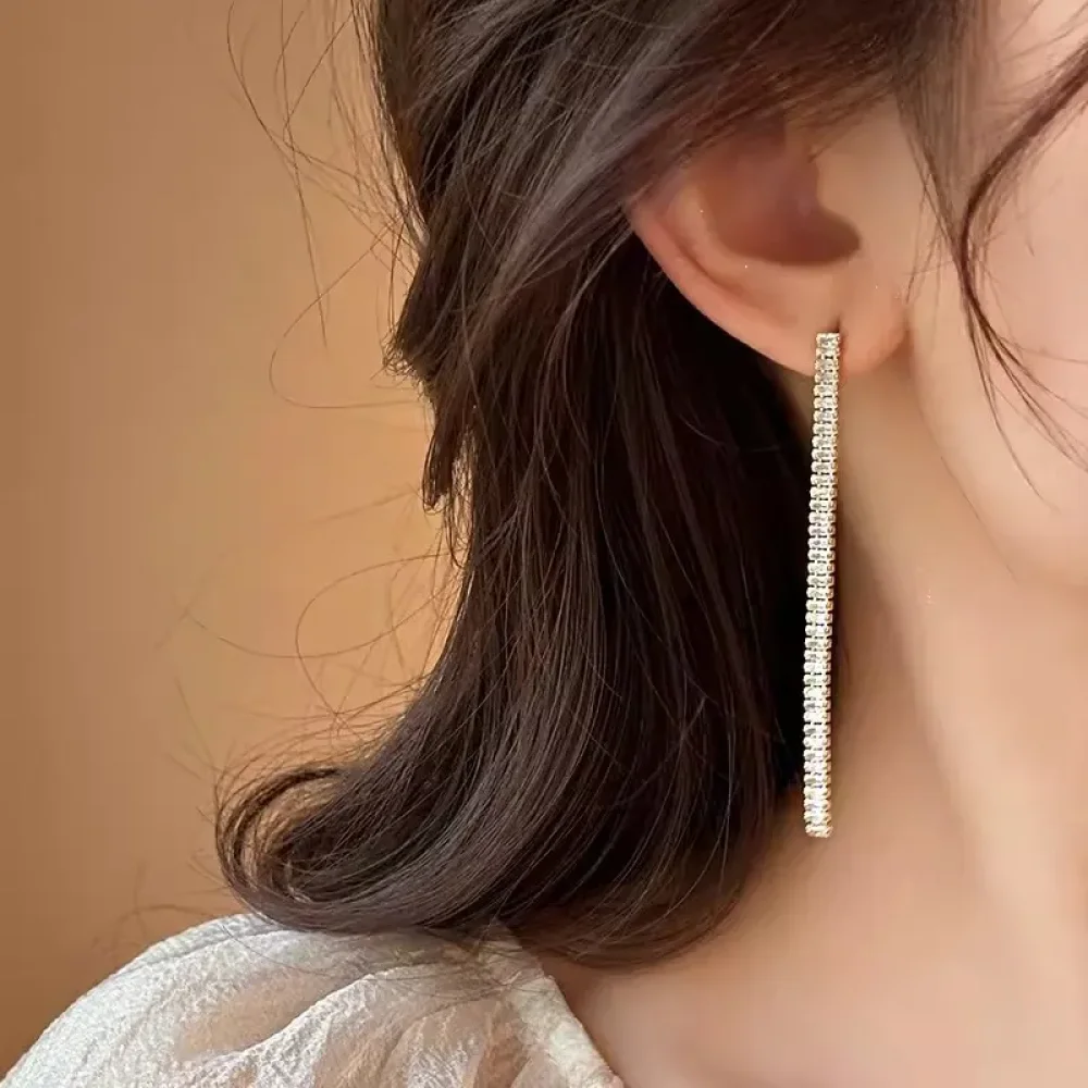 Boucle d'oreille pampille tennis dorée portée