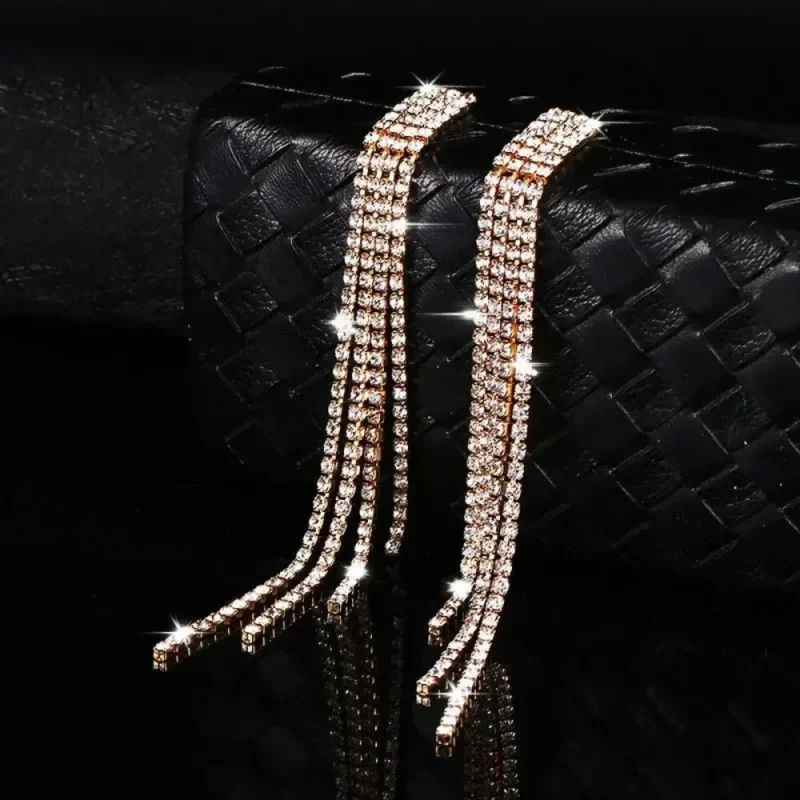 Longues boucles d'oreilles dorées à pampilles de strass