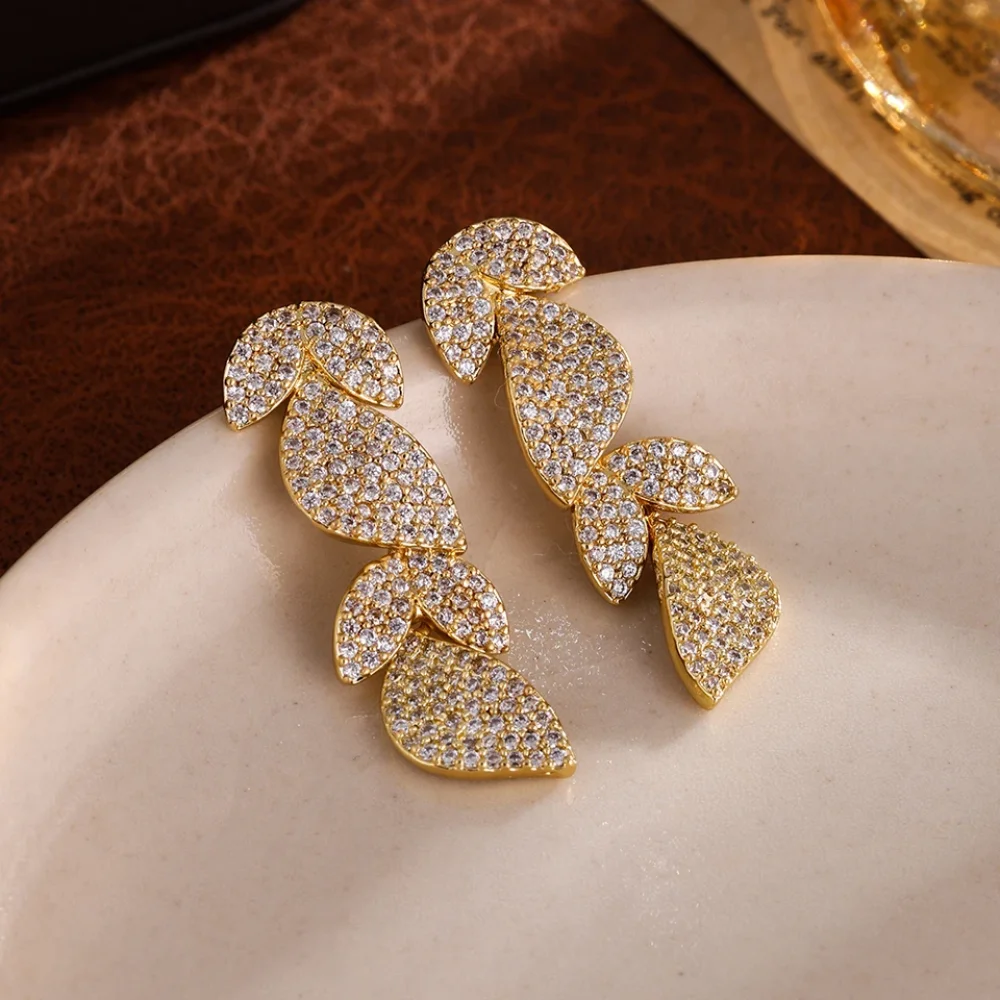 Boucles d'oreilles dorées pendantes en feuilles pavées de zircons