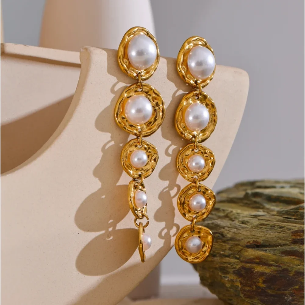 Boucles d'oreilles dorées perles en cascade sur un présentoir