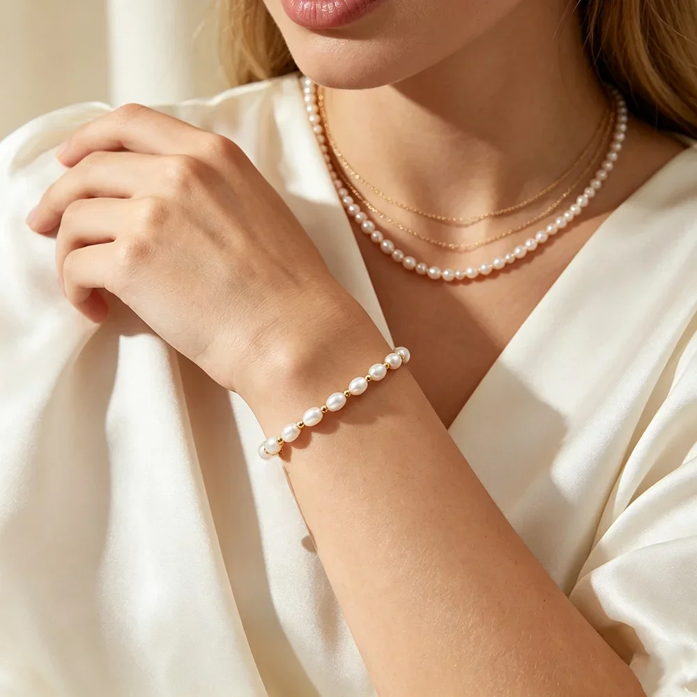 Bracelet perles d'eau douce chaîne dorée porté avec un collier