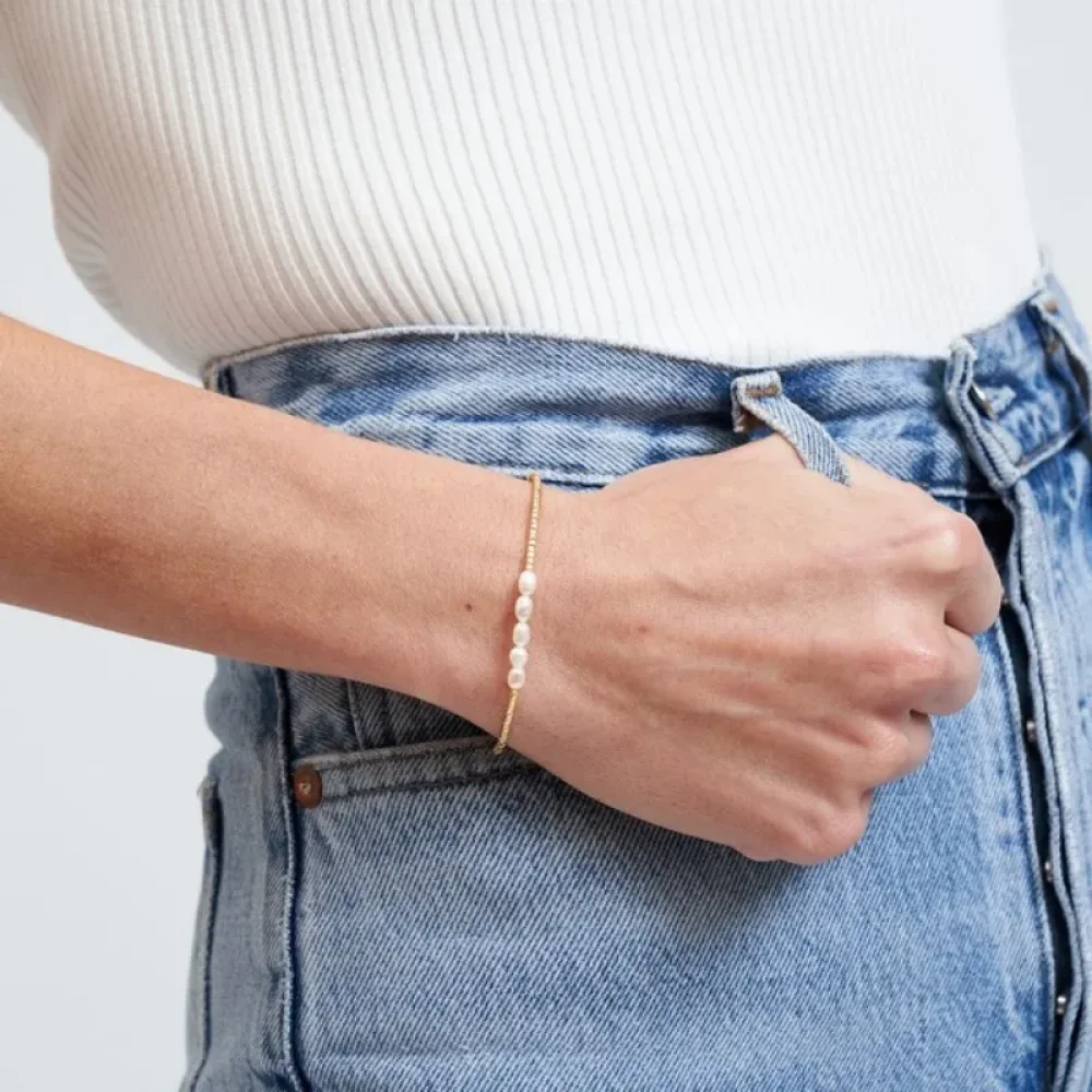 Bracelet perles Miyuki dorées porté au poignet