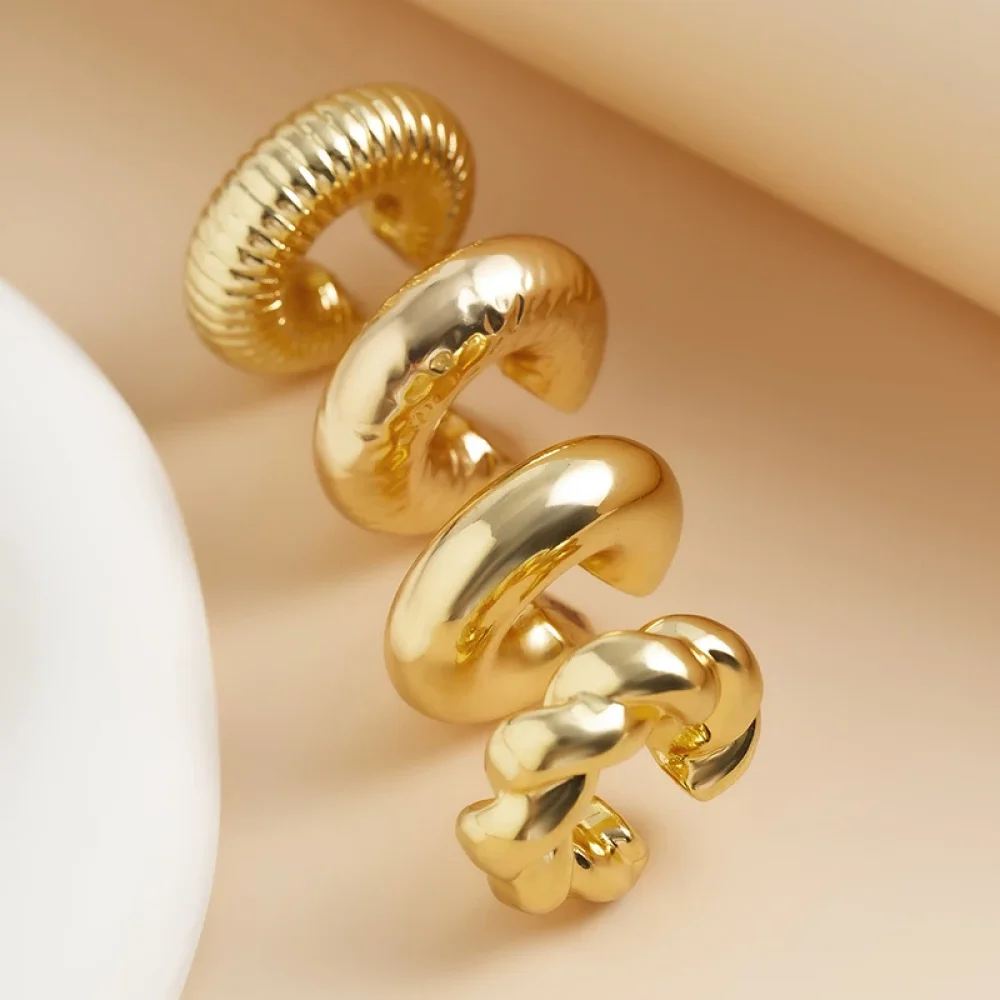 Clips d'oreilles dorés empilés, détail des motifs torsadés
