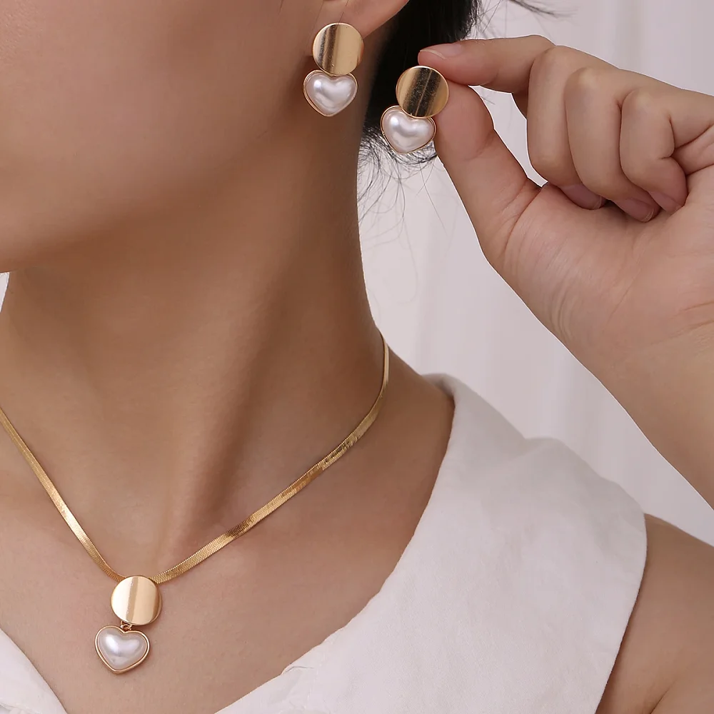 Collier doré cœur perle porté