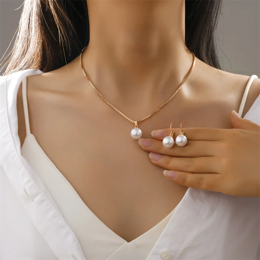 Collier doré à pendentif perle porté