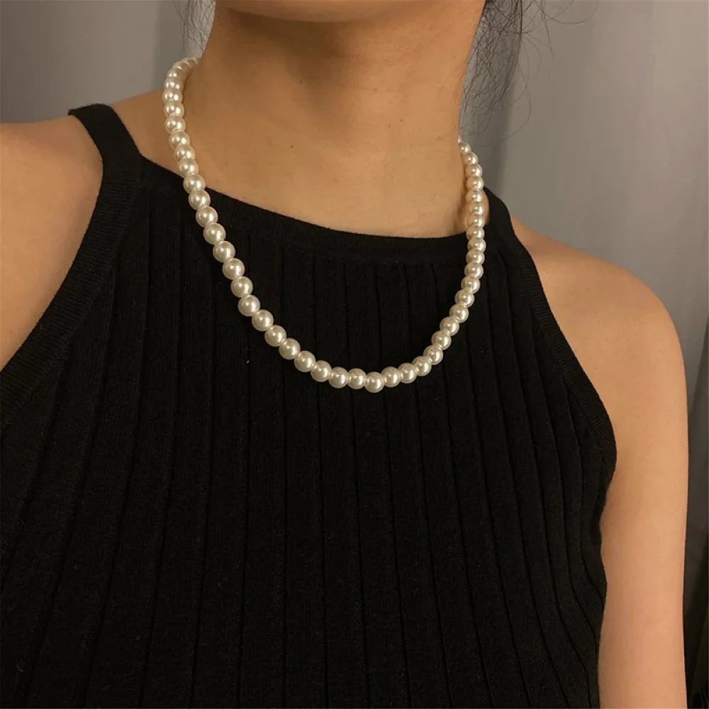 Collier de perles classique porté avec un haut noir