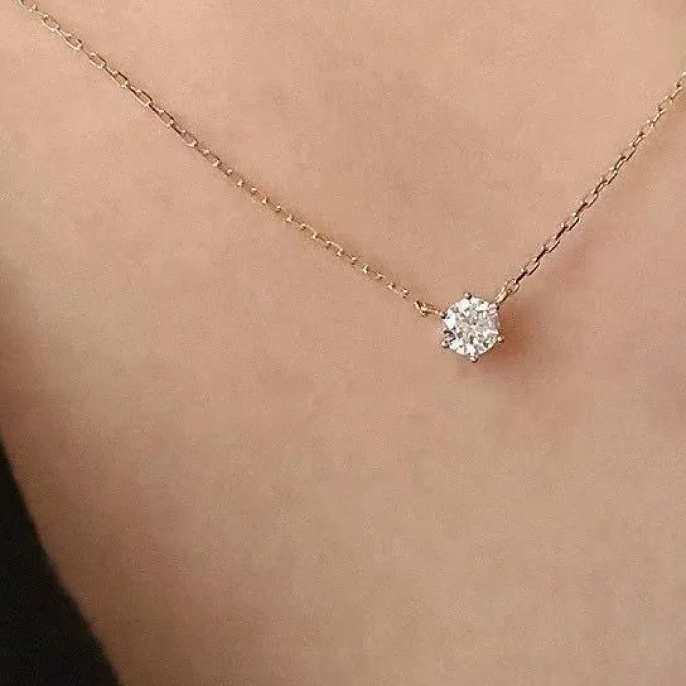 Collier solitaire zircon doré porté au cou