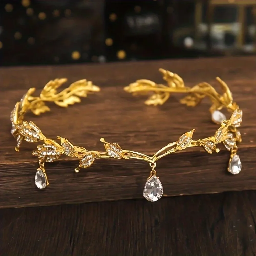 Couronne de feuilles dorées à gouttes de cristal posée sur bois