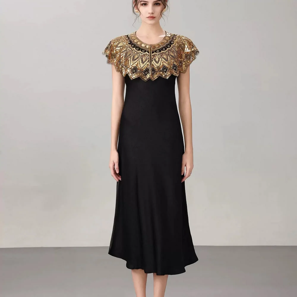 Étole cape noir et or portée avec une robe longue
