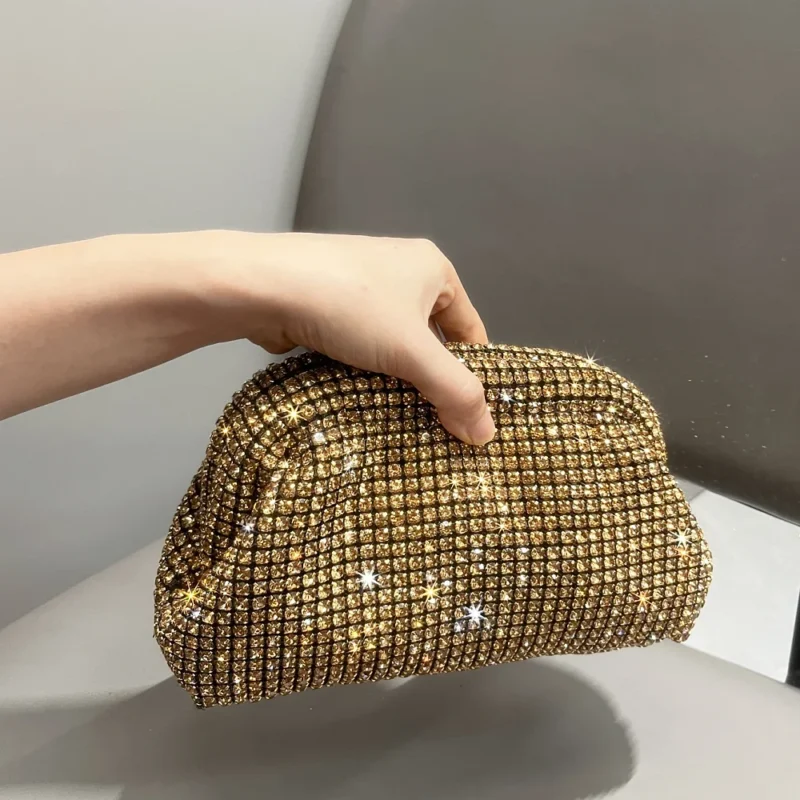 Pochette dorée couverte de strass scintillants tenue à la main