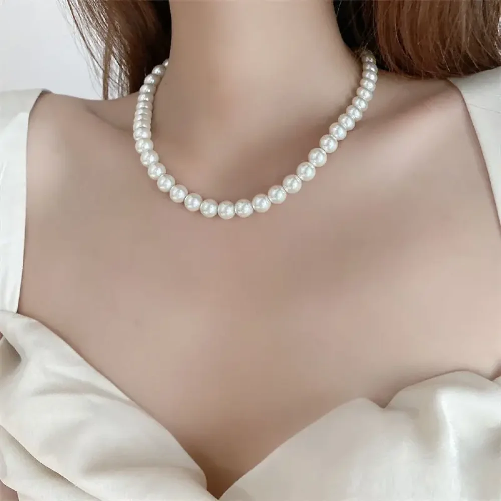Ras du cou en perles blanches porté avec un décolleté
