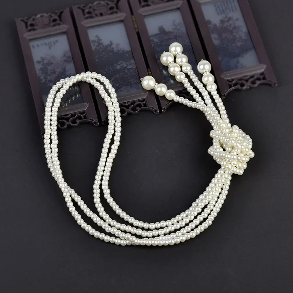 Sautoir de perles blanches 125 cm posé à plat avec son nœud