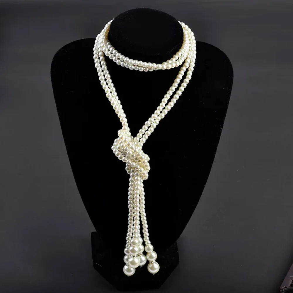 Sautoir de perles blanches noué façon Gatsby sur un buste