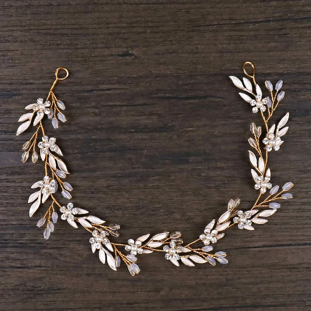 Vigne de cheveux dorée feuilles et strass posée sur bois